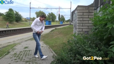 Shameless sweetie pisses near the railway even though someone can see her