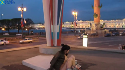 A brunette slut takes off her pants and masturbates on the city square