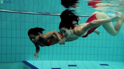 Two skinny and fresh white girls in red bikini undress in the pool