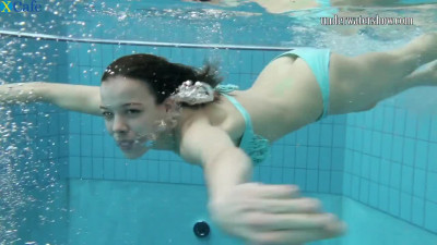 Beautiful pale skin petite brunette lady in the pool underwater