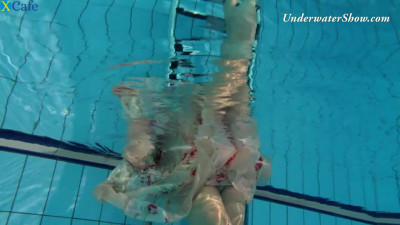 Appealing red haired Edwige swimming in a pool naked