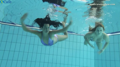 Two tempting mermaids caressing each other underwater